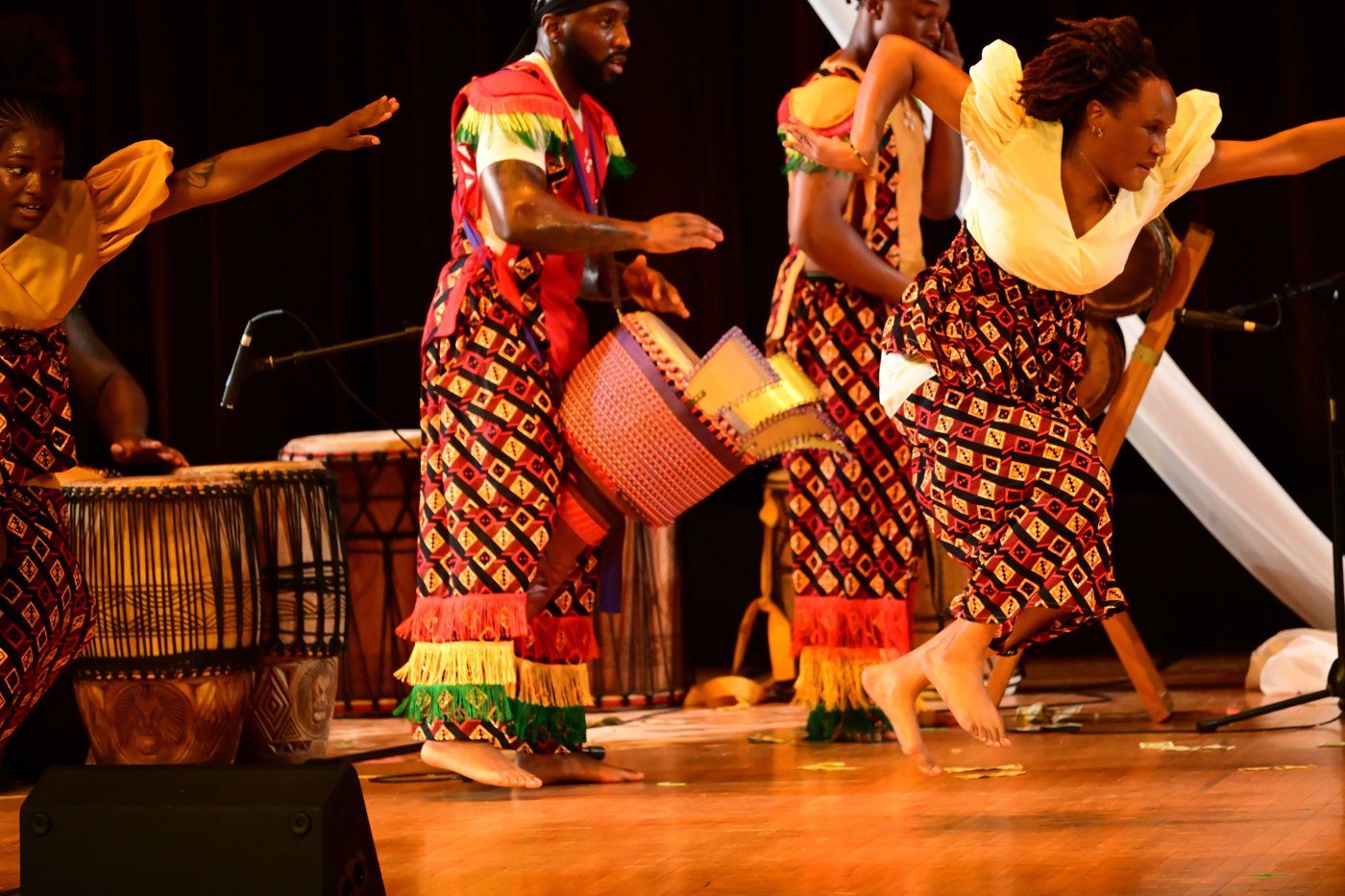 A dancer leaping in red and gold dress at Birthright