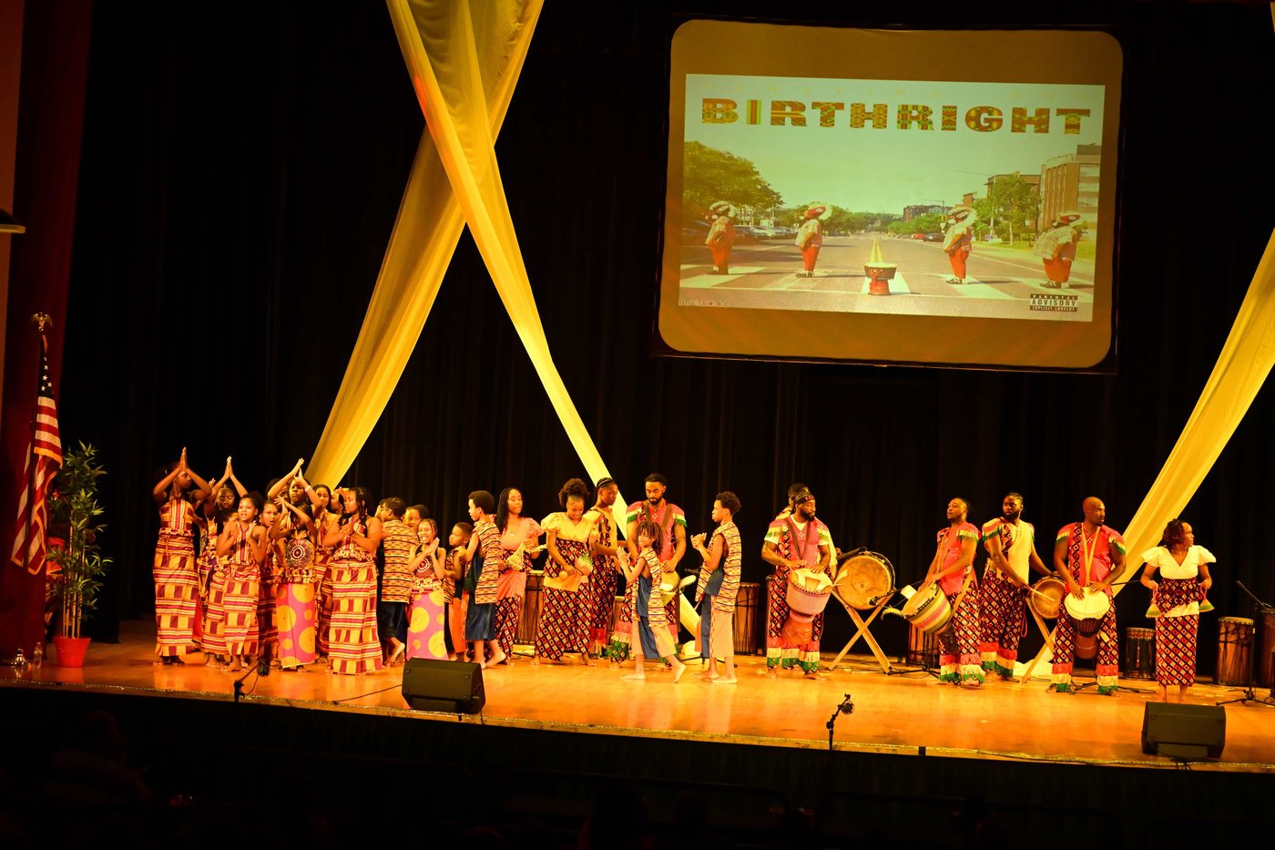 The company gathered on stage celebrating at the end of a Birthright performance