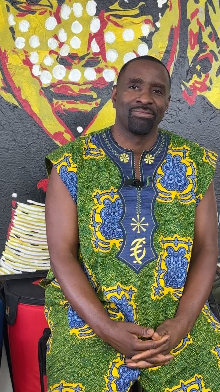 Portrait of Mahiri Fadjimba Keita, founder of Farafina Kan, in front of a colorful painted mural